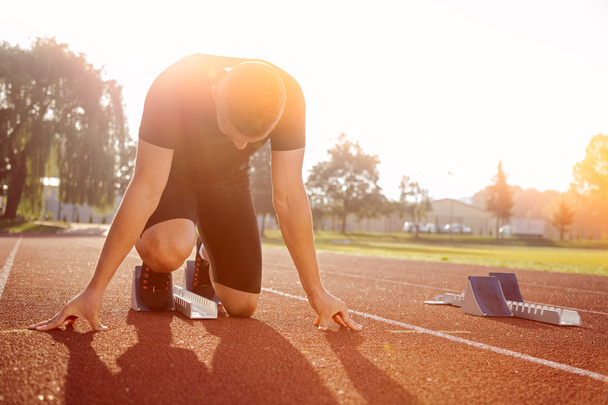 Atletik adam güneş ışınları koşu başlamak üzere - Fotoğraf, Görsel