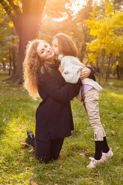 Mother with daughter seven years old in autumn Park at sunset - Foto, Bild