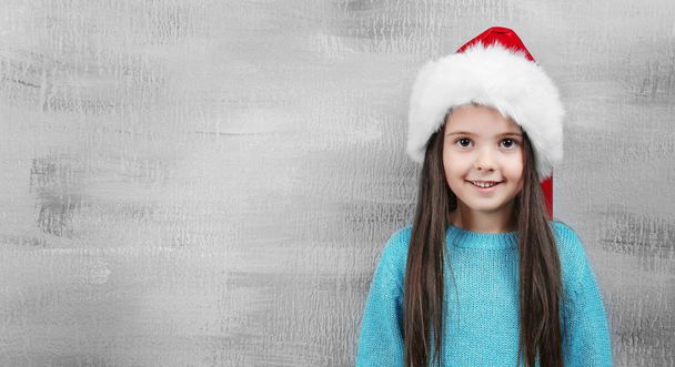 Cute little girl in Santa hat on color background - 写真・画像