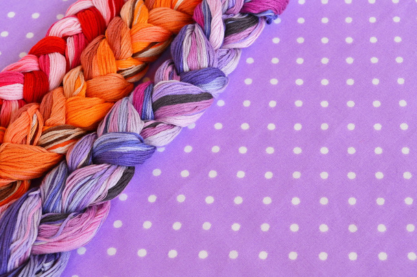 Bordado fios de cores diferentes em um fundo roxo
 - Foto, Imagem
