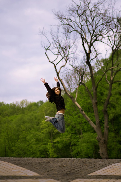 Young girl jumping in park - Φωτογραφία, εικόνα