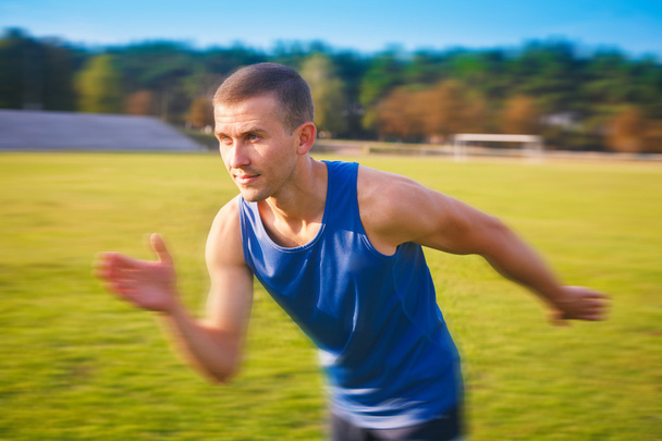 Young handsome sportsman running outdoors. - 写真・画像