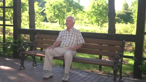 Elderly man sitting on bench. - Footage, Video
