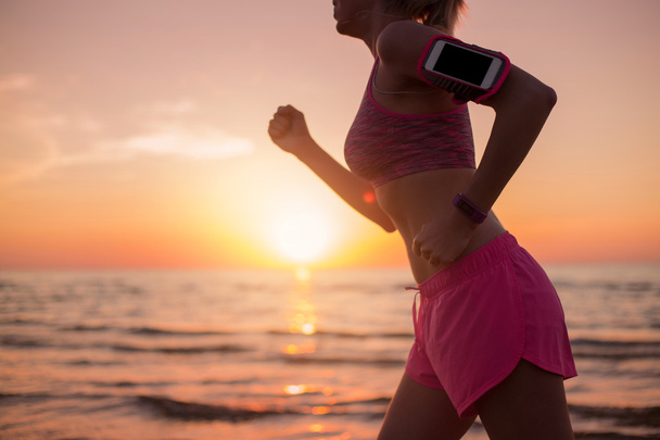 Mujer corriendo y escuchando música en el teléfono inteligente
 - Foto, Imagen