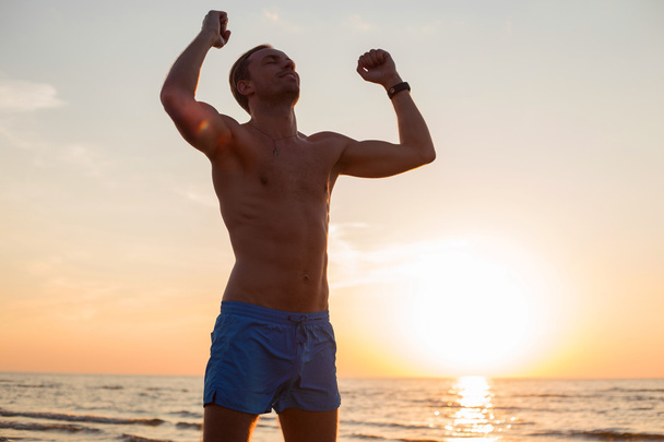 Szczęśliwy człowiek, po treningu stojący w zachodzie słońca - Zdjęcie, obraz