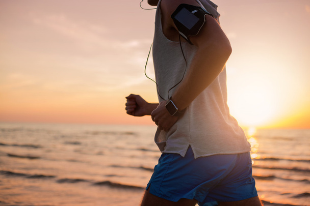 Man running on the beach and listening music  - Fotografie, Obrázek