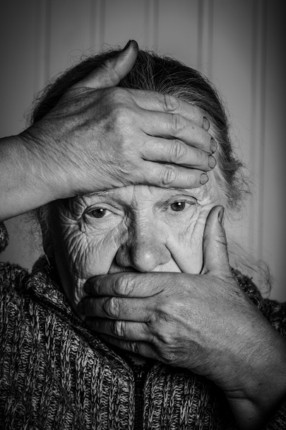 Ritratto di una donna anziana con le mani vicino al viso su un bac leggero
 - Foto, immagini