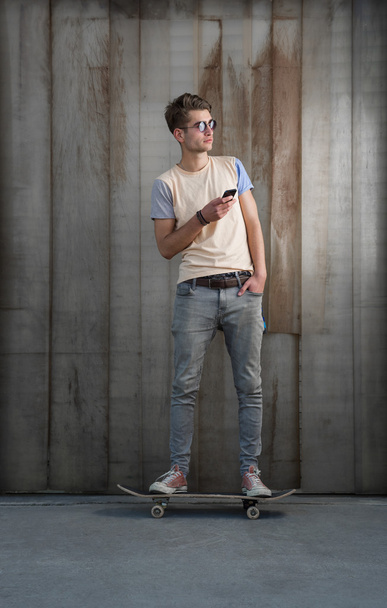 Teenage skater boy using smartphone  - Valokuva, kuva