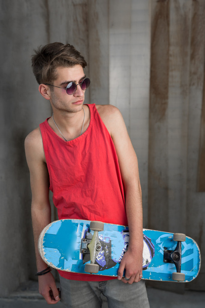 Young man with blue skateboard - Zdjęcie, obraz