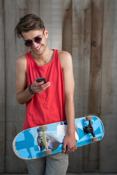 Teenage skater boy using smartphone  - Foto, Imagen