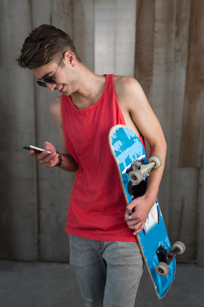 Teenage skater boy using smartphone  - Fotoğraf, Görsel