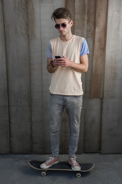 Teenage skater boy using smartphone  - 写真・画像