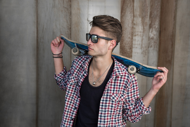 Young man holding skateboard - 写真・画像