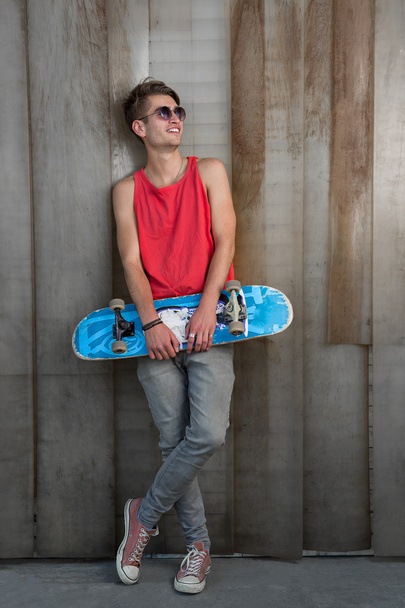man in red with blue skateboard - Фото, зображення