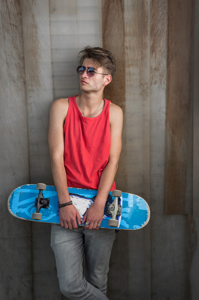 man in red with blue skateboard - Фото, изображение