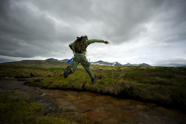 muž tramp skákání přes malé řeky - Fotografie, Obrázek