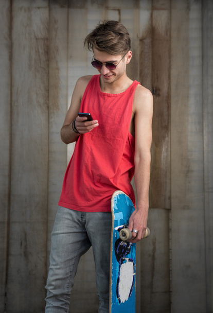 Teenage skater boy using smartphone  - Fotografie, Obrázek