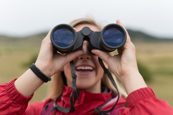 Woman with binoculars hiking in mountains - Photo, Image