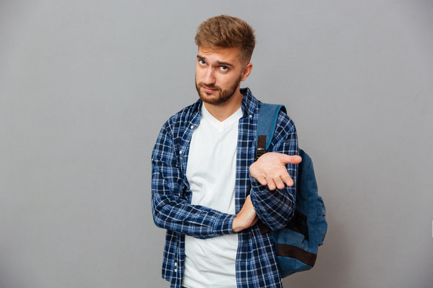Portrait of a hipster man standing with open palm - Фото, изображение