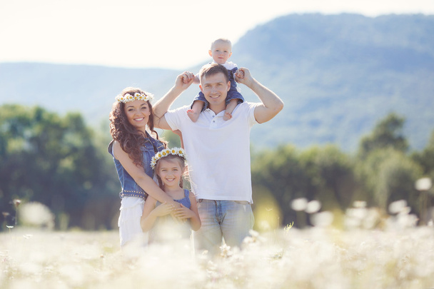Famiglia felice su un campo di margherite fiorite
 - Foto, immagini