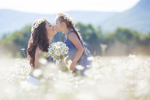 Mother and daughter in summer field of blooming daisies - Foto, immagini