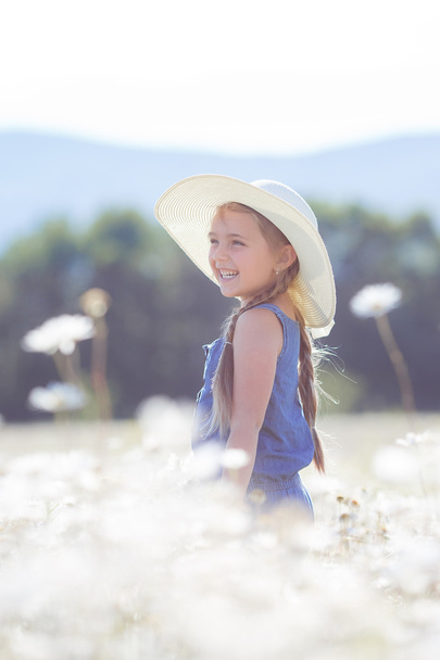 Summer portrait of a little girl in a field of white daisies. - Foto, immagini