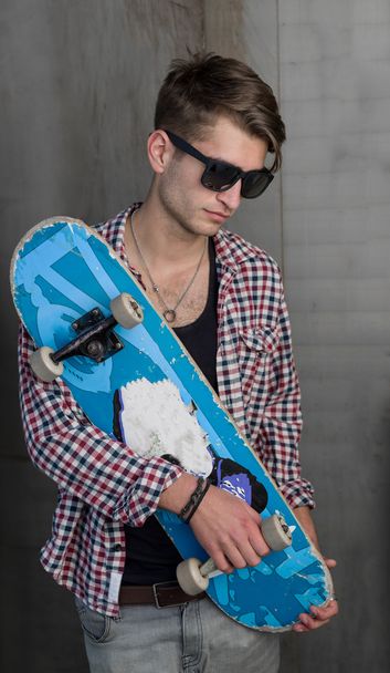 fashion man holding skateboard - Fotó, kép