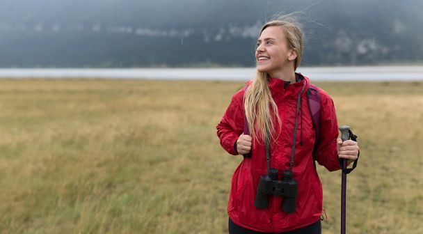 Woman with binoculars hiking in mountains - Foto, Imagen