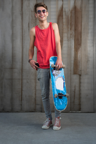 Teenage skater boy using smartphone  - Foto, Bild