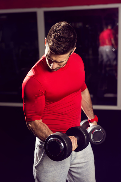 Hombre musculoso trabajando con pesas
 - Foto, imagen