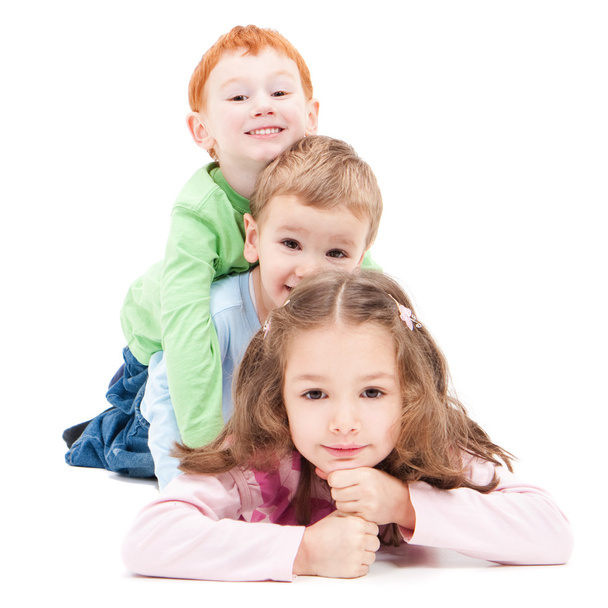 Three smiling kids lying on top of each other - Photo, image