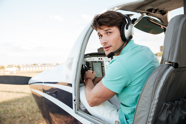 Man pilot sitting in cabin of small airplane - Photo, Image