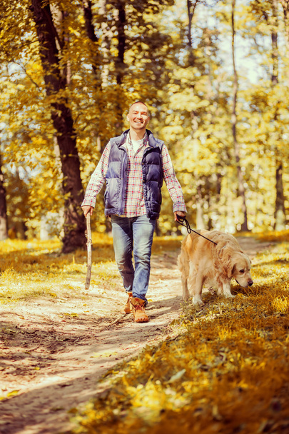 Young man walking a dog at the park - Fotografie, Obrázek