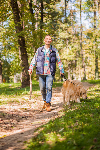 Young man walking a dog at the park - Foto, Imagen