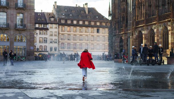 Cute little girl playing in water splash of street fountain - Foto, immagini