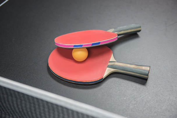 table tennis racket with orange ball on black  - 写真・画像