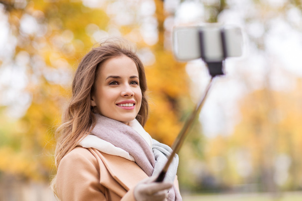 woman taking selfie by smartphone in autumn park - Photo, Image