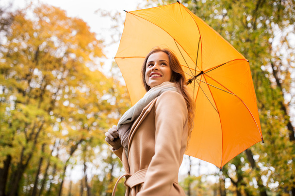 happy woman with umbrella walking in autumn park - Foto, Imagem