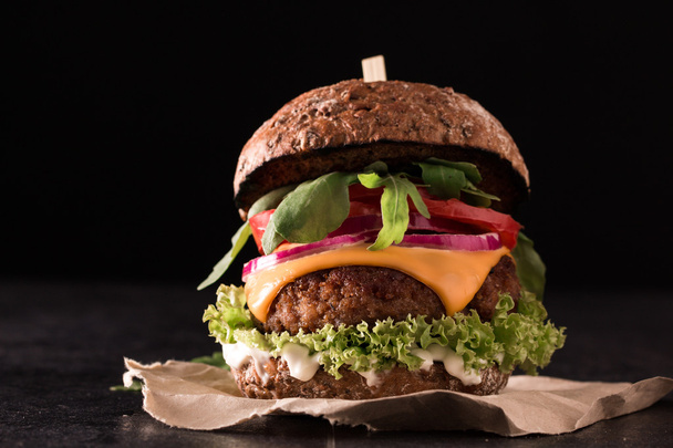 Tasty grilled burger with lettuce and mayonnaise ,on blackboard table - Fotoğraf, Görsel