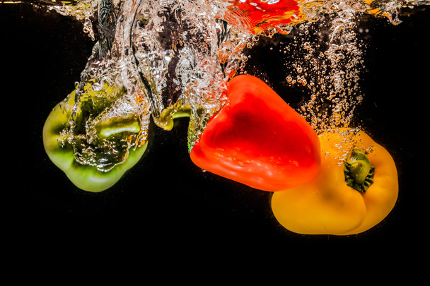 splashing bell peppers on water - Foto, Imagem