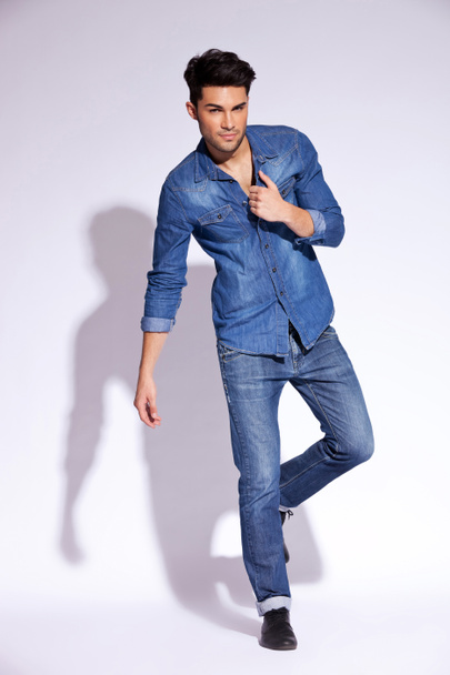 Мужчина, держащий джинсовую рубашку за воротник
 - Фото, изображение