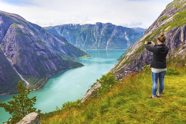 Female tourist hiking in high norwegian mountains over a fjord - Fotografie, Obrázek