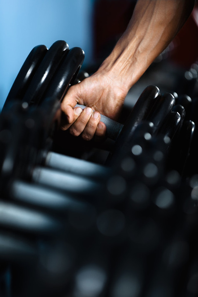 Hand taking out a dumbbell - Foto, immagini