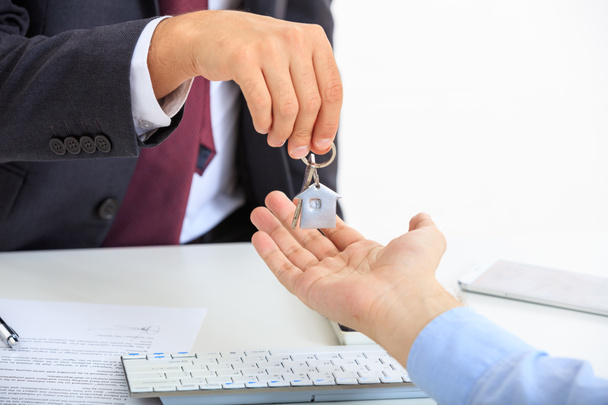 Man in suit offering a key - Photo, Image