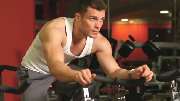 przystojny mężczyzna sportowy jest ćwiczenia w siłowni centrum - Materiał filmowy, wideo