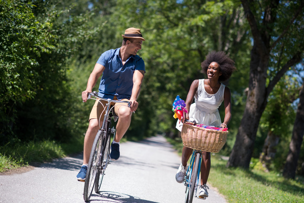 Молодая многонациональная пара, путешествующая на велосипеде по природе
 - Фото, изображение