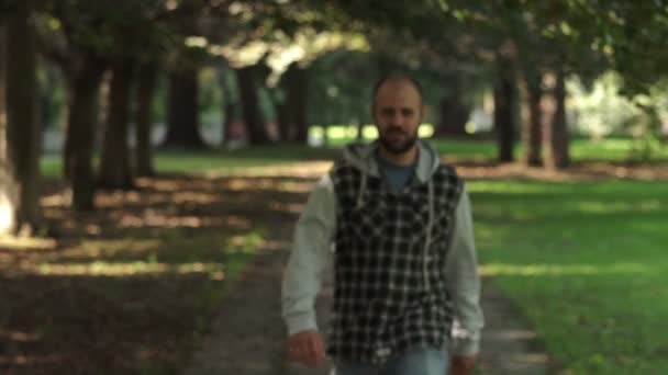 defiant man in the park proudly looks at the camera - Filmagem, Vídeo