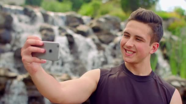 Selfie gay. Un gay qui prend du selfie au parc. Homme caucasien prenant des photos avec téléphone
 - Séquence, vidéo