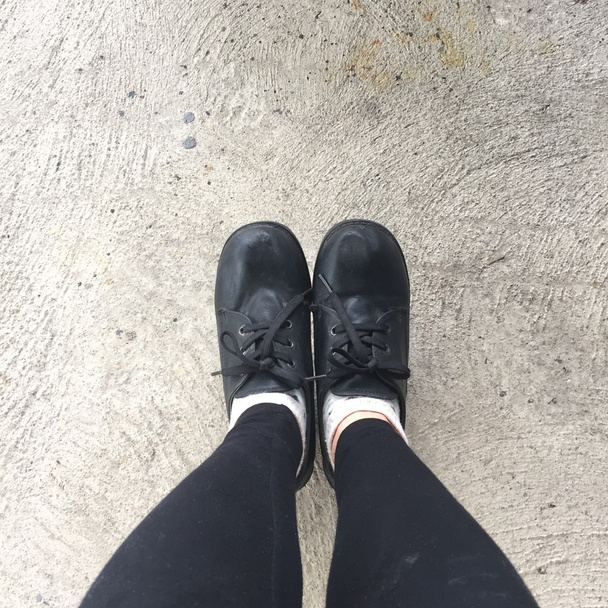Selfie Füße tragen schwarzen Schuh für Frau auf dem Boden Hintergrund  - Foto, Bild