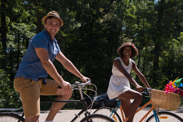 Joven pareja multiétnica teniendo un paseo en bicicleta en la naturaleza
 - Foto, imagen